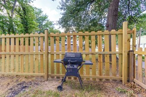A barbecue grill in front of a wooden fence. - Walk Everywhere! Downtown Fort Smith Duplex (Fort Smith)
