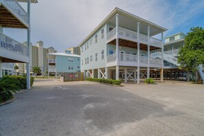 Een hotel met meerdere verdiepingen, balkons, een overdekt buitengebied en een parkeerplaats.