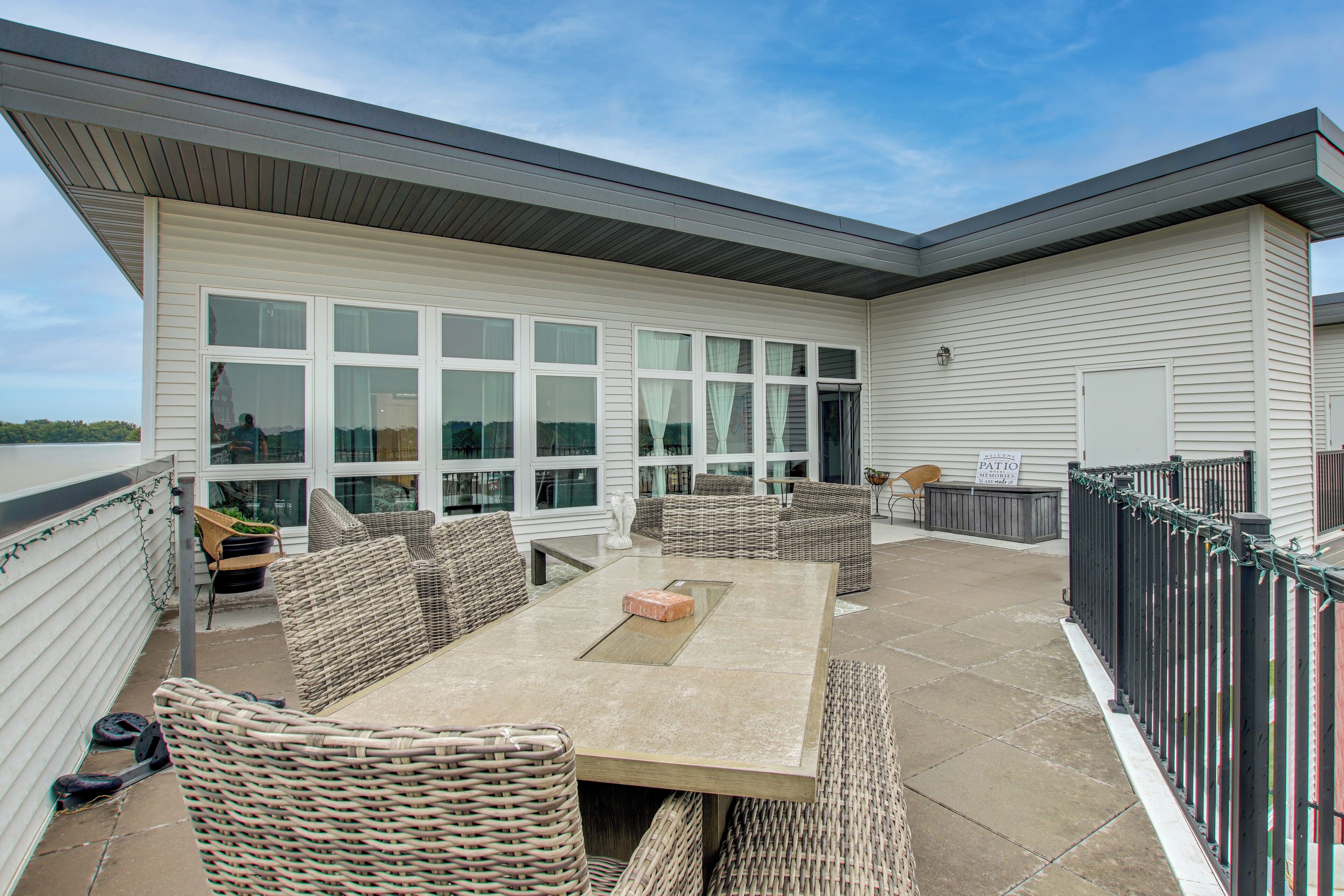 A patio area with a table and chairs, a view of the building's exterior, and a sign welcoming visitors to the patio.