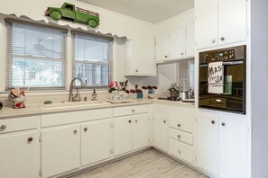 A kitchen with white cabinets, a sink, and a green toy truck decoration. - Lenoir Home w/ Home Office Near Blowing Rock (Lenoir)