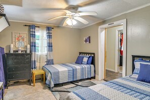 A bedroom with two beds, a ceiling fan, a dresser, and a window with curtains. - Wraparound Porch! Quiet Country Home, 9 Mi to MSU (Starkville)