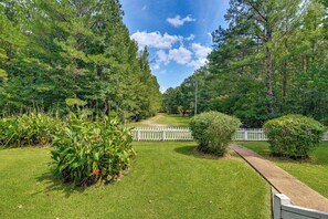 A well-maintained garden with a white picket fence, lush greenery, and a clear sky. - Wraparound Porch! Quiet Country Home, 9 Mi to MSU (Starkville)