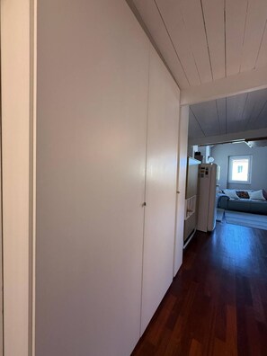 A hallway with a wooden floor leading to a living area with a sofa and a window. - Marvelous 1-bedroom apartment with AC in vibrant Cagliari (Cagliari)