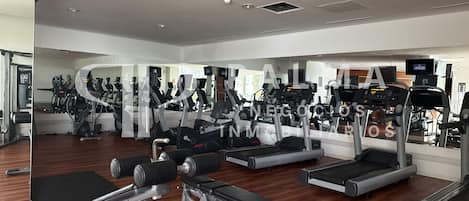 A gym with cardio machines, weightlifting equipment, and mirrors.