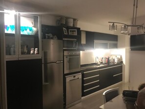 A modern kitchen with stainless steel appliances, a microwave, and a dishwasher. - Charming 2-Bedroom Apartment at Parada 6 Brava, Punta del Este (Punta del Este)