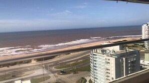 A coastal view with a beach, road, and modern buildings. - Charming 2-Bedroom Apartment at Parada 6 Brava, Punta del Este (Punta del Este)