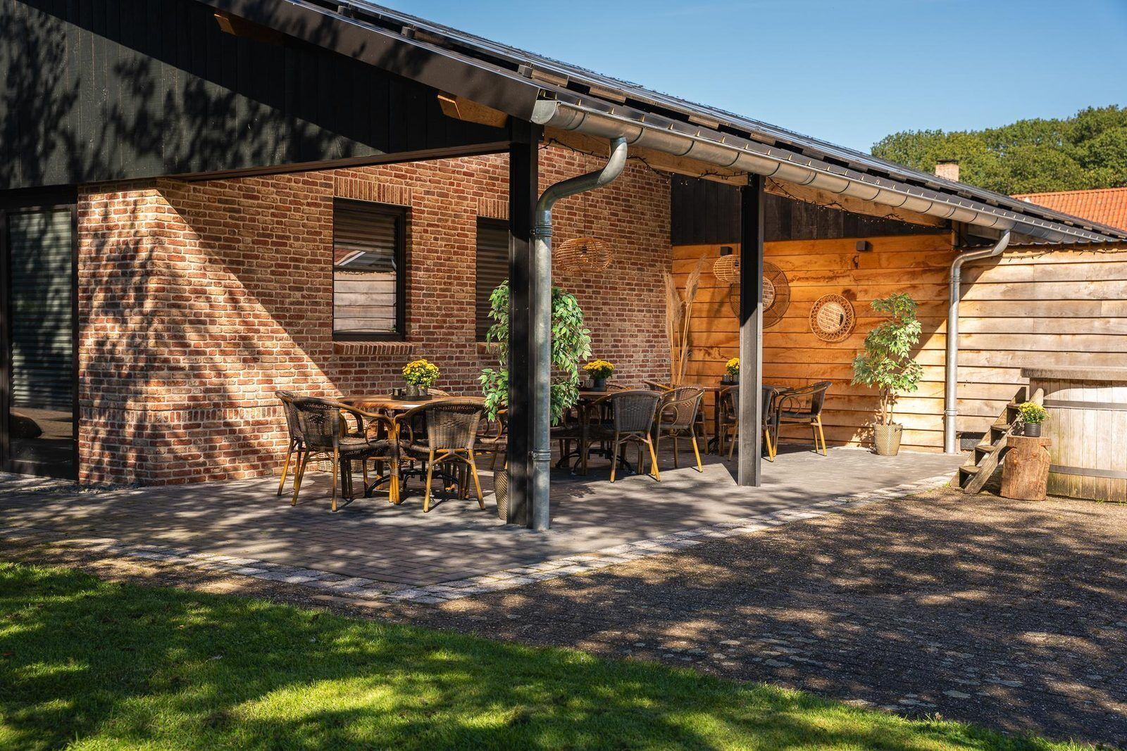 Un bâtiment en briques doté d’un patio couvert avec des espaces aménagés pour s’asseoir à l’extérieur.