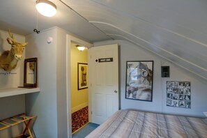 A room with a bed, a mounted deer head, a framed picture, and a door labeled 'HOT OWL'. - Downtown Spacious 5BR w/ Game Room (Ellicottville)