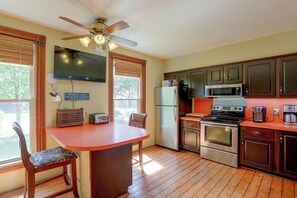 A kitchen with a central island, a refrigerator, a microwave, an oven, and a ceiling fan. - Downtown Spacious 5BR w/ Game Room (Ellicottville)