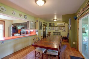 A kitchen with a dining table, chairs, and a refrigerator.