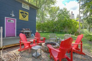 A blue building with a police sign, outdoor seating with red chairs, and a fire pit. - Downtown Spacious 5BR w/ Game Room (Ellicottville)