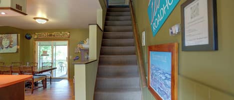 A staircase leading to a second floor with a view of a snowy landscape.
