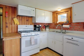A compact kitchen with a stove, oven, microwave, and dishwasher. - Carley House Too: Pet Friendly, Hot Tub, Fire Pit! (Little Valley)