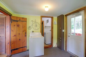 A laundry room with a washing machine, dryer, and a bicycle wall decoration. - Carley House Too: Pet Friendly, Hot Tub, Fire Pit! (Little Valley)
