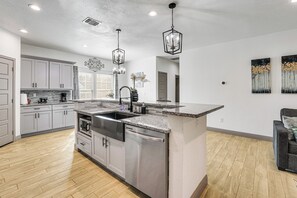 A modern kitchen with stainless steel appliances, a granite countertop, and pendant lighting. - Walk to Parks & Dining! Universal City Home (Universal City)