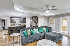 A modern living room with a sectional sofa, a marble coffee table, and a kitchen in the background. - Extended Stay Gem Near Redstone Arsenal & Airport (Madison)