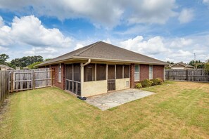 A single-story house with a covered patio, a fenced backyard, and a clear sky. - Extended Stay Gem Near Redstone Arsenal & Airport (Madison)