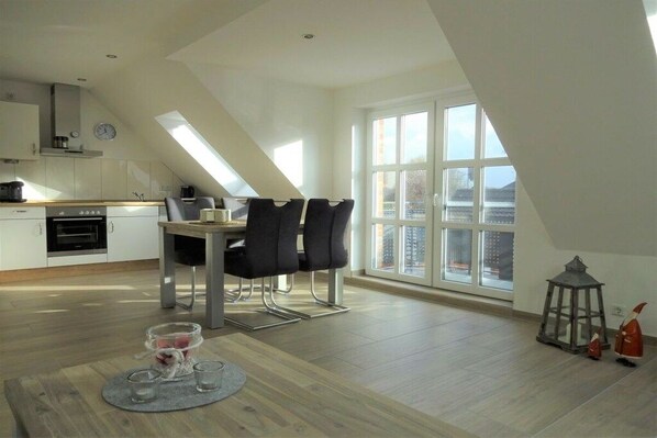 Eine moderne Küche mit Essbereich, großen Fenstern und Blick auf die Stadt.