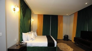 Une chambre d’hôtel moderne dotée d’un grand lit, d’une télévision et d’un petit coin salon.