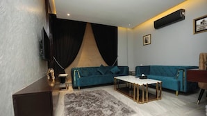 Un salon moderne avec un canapé, une table basse et un téléviseur.