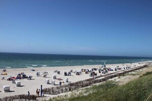 A beach with numerous beach chairs and umbrellas, a sandy shore, and the ocean in the background. - Holiday home in Hörnum with 3 bedrooms (Hörnum \/ Sylt)