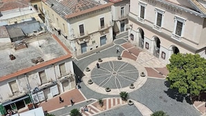 Uma praça com um desenho circular central, rodeada por edifícios de arquitetura tradicional.