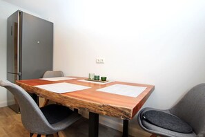 Taula de dinar amb papers, dues cadires, un armari i una presa de corrent a la paret.