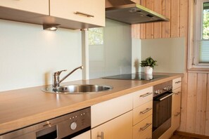 Eine moderne Küche mit Edelstahlgeräten, Holzschränken und einem Fenster für natürliches Licht.