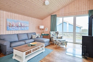 Ein gemütliches Wohnzimmer mit Sofa, Sessel und Couchtisch.