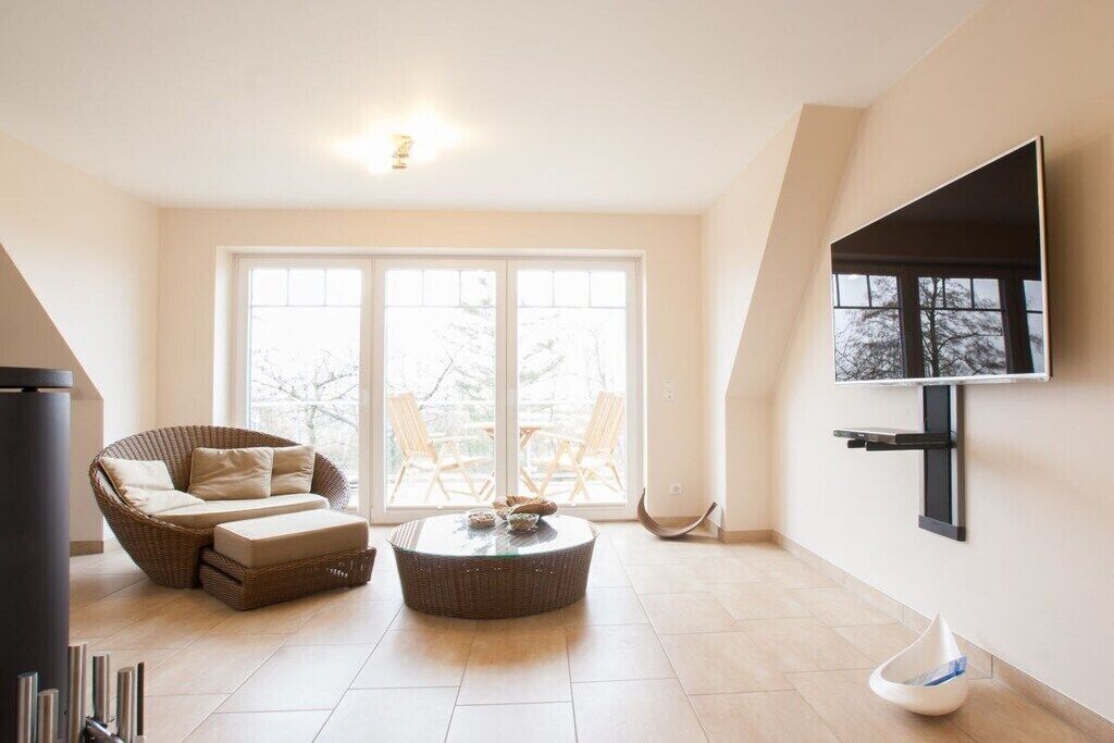 A modern living room with a sofa, a coffee table, and a TV mounted on the wall.