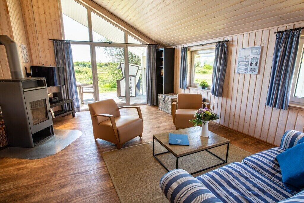 Una sala de estar acogedora con chimenea, asientos cómodos y vistas amplias a través de grandes ventanales.