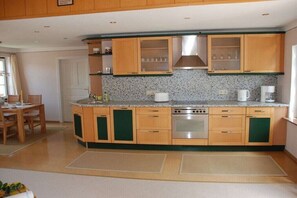 A kitchen with wooden cabinets, a stainless steel oven, and a granite countertop. - Holiday apartment with 1 bedroom (Husum\/ Nordsee)