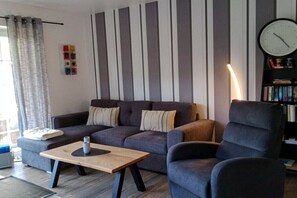 Una sala de estar moderna con un sofá, un sillón y una mesita de centro.