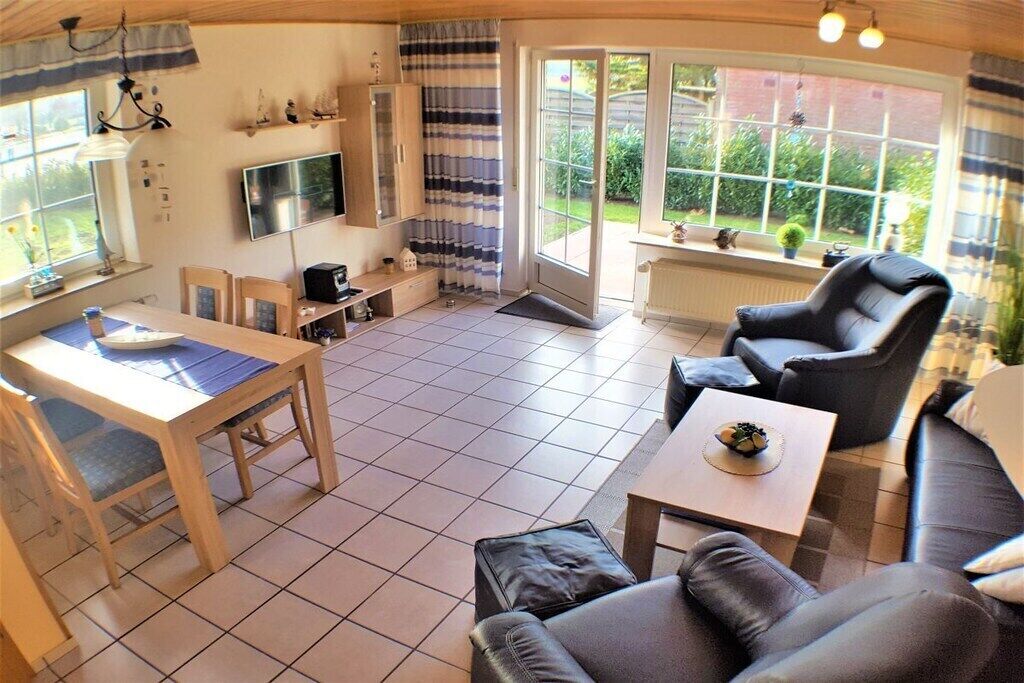 A cozy living room with a sofa, a dining table, and a TV.