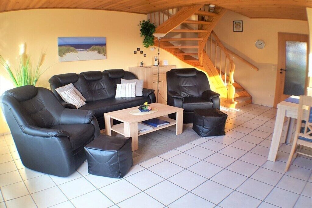 Un salon comprenant un canapé, une table basse et un escalier.