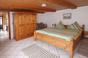 A bedroom with a wooden bed, a wardrobe, and a small table. - Holiday apartment with 1 bedroom (Gadendorf)