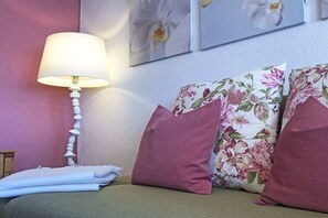 A room with a bed, a lamp, and floral artwork on the wall. - Rikate in Kappeln on the Schlei (Kappeln Stadt)