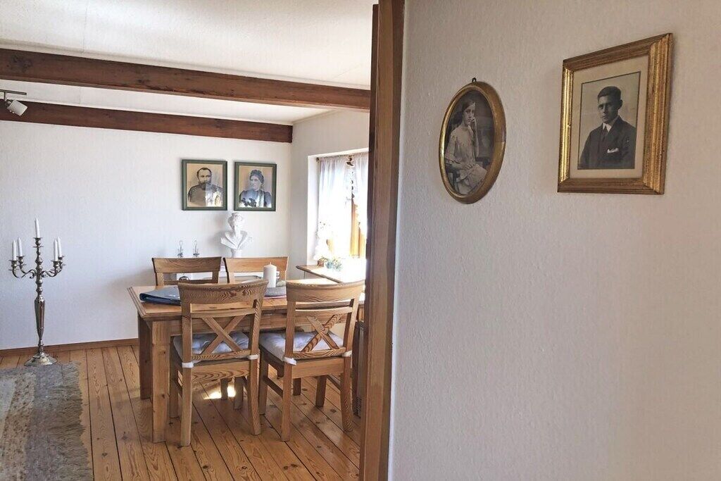 Ein Essbereich mit Holzmöbeln und gerahmten Bildern an der Wand.