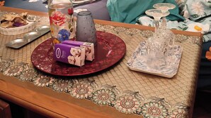 Una mesa de comedor con una botella, una copa y un plato con comida.
