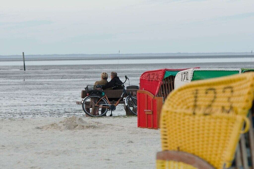A beach scene with a bicycle and a red structure.
