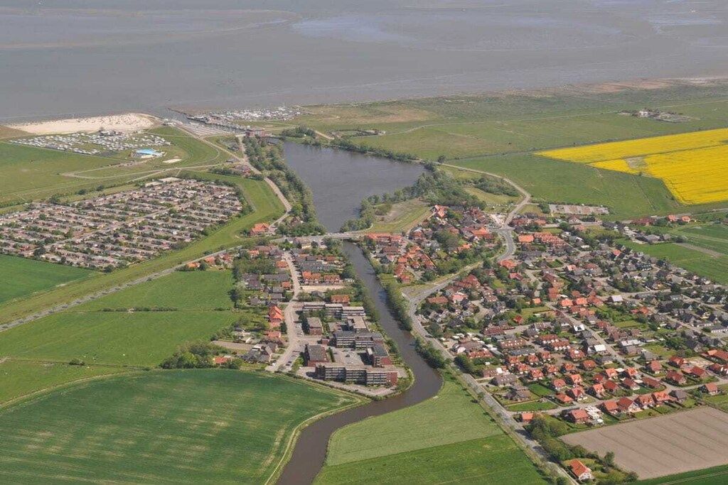 A residential area with houses, a river, and agricultural fields.