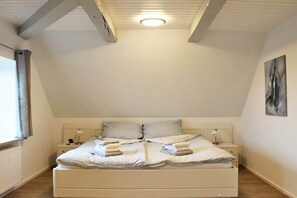 Ein Schlafzimmer mit einem Bett, Nachttischen und einem Bild an der Wand.
