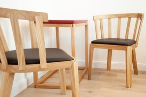 Two wooden chairs with black cushions, a small wooden table, and a light-colored floor. - Holiday apartment with 1 bedroom (Kappeln Stadt)