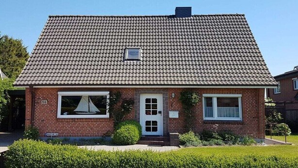 A single-story brick house with a tiled roof, a front door, and a small window. - Holiday home Seestern (Hasselberg)