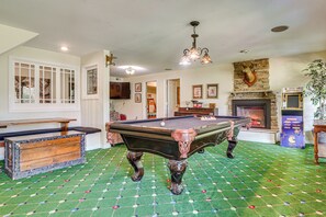 A billiards room with a pool table, a fireplace, and a vintage arcade machine. - Hot Tub Ski Home: Rooster's Den in Ellicottville (Ellicottville)