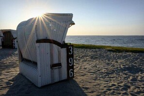 A wicker chair with a number '396' on a sandy beach with a view of the sea. - Holiday apartment with 2 bedrooms (Carolinensiel)