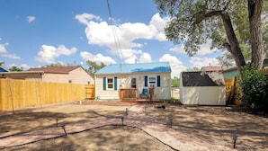 A residential property with a fenced backyard, a covered porch, and a detached garage.