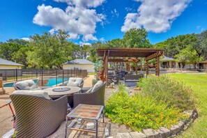 Ein Garten mit Pool, Sitzgelegenheiten und einer Pergola.