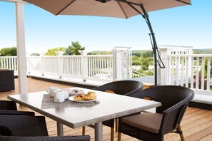 An outdoor patio with a table, chairs, and an umbrella. - Villa Ocean Time WHG 17 (Haffkurg)
