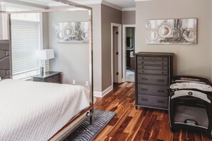 Ein Schlafzimmer mit einem Bett, einem Schminktisch und Bildern an den Wänden.